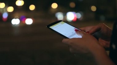 Geceleri sokakta cep telefonunda kadın manifatura