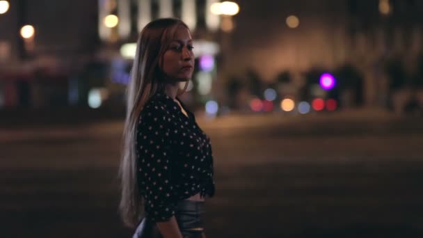 Mujer joven caminando por una calle nocturna de la ciudad — Vídeo de stock