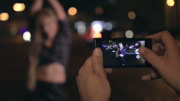 Ung man gör bilder av sin flickvän på natten — Stockvideo