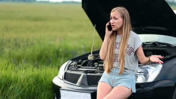 Mujer molesta hablando por teléfono cerca de coche roto — Vídeo de stock