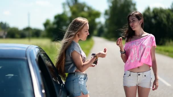 Jovens mulheres comendo e bebendo café perto do carro — Vídeo de Stock