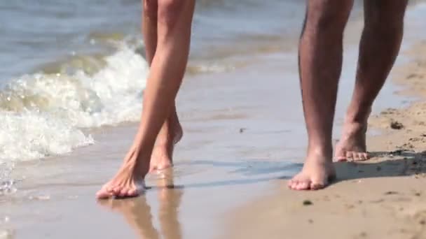 Primo piano di piedi che camminano in riva al mare bordo sulla spiaggia — Video Stock