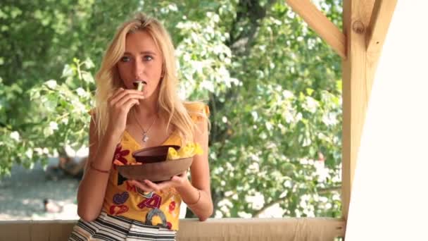 野菜を食べてビーチでセクシーな笑顔の女性 — ストック動画