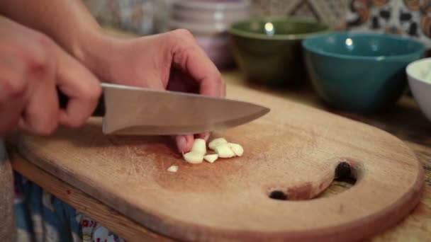 Mains de femme hacher l'ail frais avec un couteau — Video