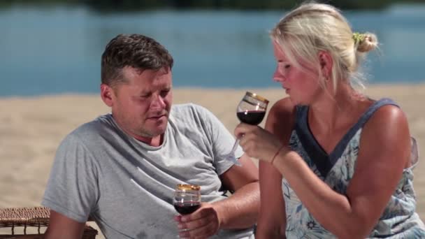 Улыбающаяся пара наслаждается пикником на пляже — стоковое видео