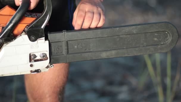 Widok mężczyzny trzymającego chainsaw z bliska — Wideo stockowe