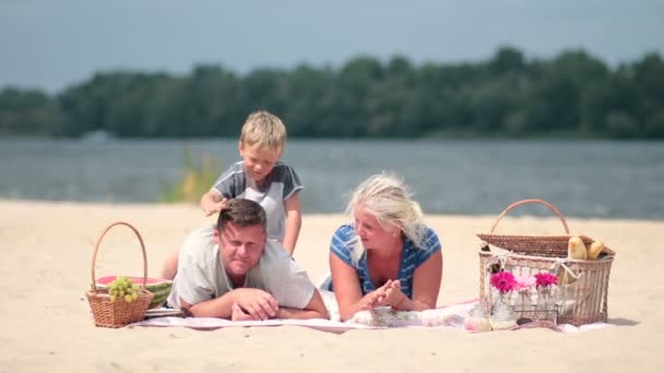 Young family enjoying weekend on river bank — Stock Video