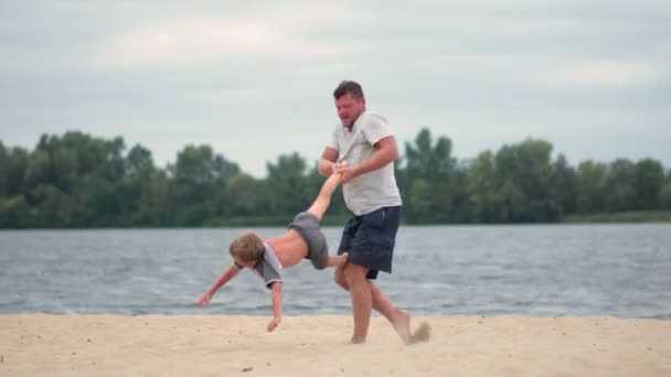 Mutlu baba ve oğul yaz sahilde oynarken — Stok video