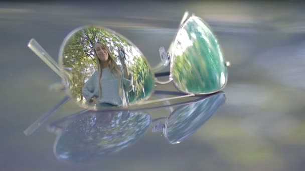 Віддзеркалення в сонцезахисних окулярах жінки, що тримає ключі від автомобіля — стокове відео