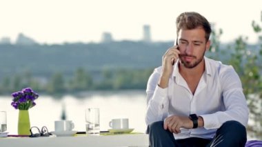 Dışarıda telefonla konuşan yakışıklı bir adam.