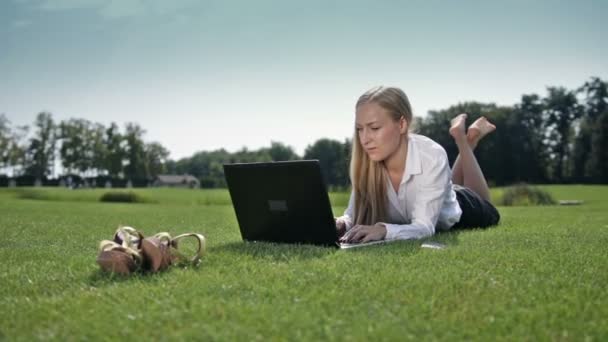 Femme d'affaires couchée sur l'herbe verte avec ordinateur portable — Video