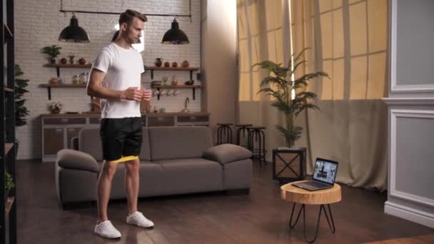 Fiatal sportos férfi az online edzés során otthon — Stock videók