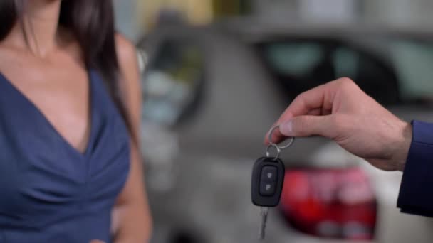 Hand des Autohändlers übergibt Autoschlüssel an Käuferin — Stockvideo