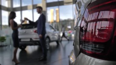 Bulanık satıcı yeni araba sahibine anahtarı veriyor.
