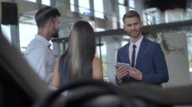 Galeride araba seçen çekici genç çift.