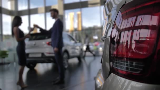 Zamazany sprzedawca daje klucz do nowego właściciela samochodu kobiety — Wideo stockowe