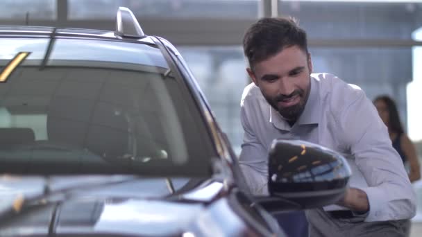 Homem feliz olhando para o carro de sonho em auto showroom — Vídeo de Stock