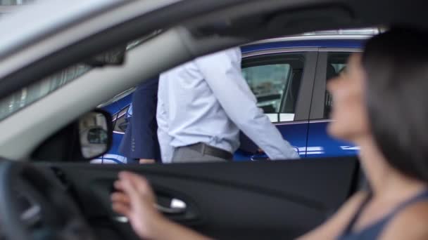 Kupujący testujący samochody od wewnątrz w salonie samochodowym — Wideo stockowe