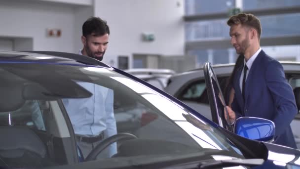 Homem comprador testando carro dentro em concessionária de automóveis — Vídeo de Stock