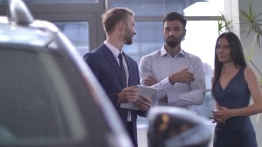 Otomobil satıcısı yeni araba seçiminde müşterilere danışmanlık yapıyor