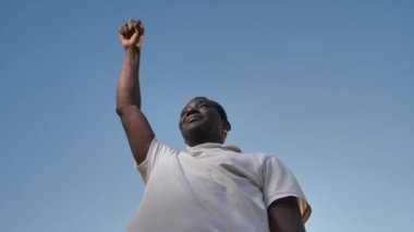 Afrika kökenli Amerikalı adam yumruğunu dışarı kaldırıyor.