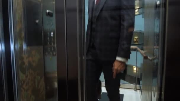 Hombre de negocios seguro saliendo del ascensor del hotel — Vídeos de Stock