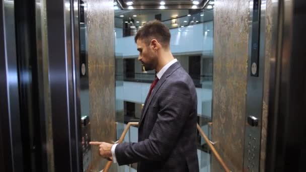Szanowny człowiek uruchamiający windę hotelową, by wejść na górę. — Wideo stockowe