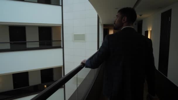 Male guest walking along balcony of hotel corridor — Stock Video