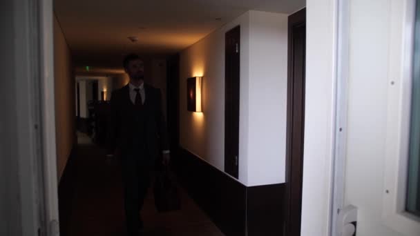 Hombre caminando por el pasillo del hotel y sala de apertura — Vídeos de Stock