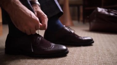 Dışarı çıkmadan önce bağcıklarını bağlayan adamın elleri