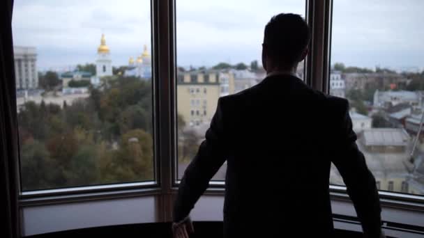 Silhoutte of man pulling curtains in hotel room — Stock Video