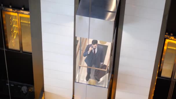 Druk op de telefoon man neemt hotel lift naar boven — Stockvideo