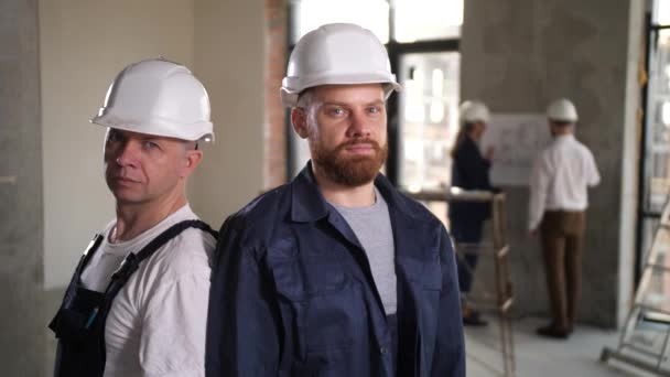 Trabalhadores confiantes posando em apartamento renovado — Vídeo de Stock