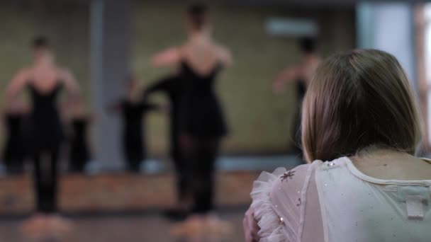 Meisje kijken ballerina 's training in danszaal — Stockvideo