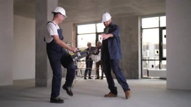 Cheerful workers dancing during renovation work