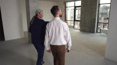 Realtor showing flat and view from window to buyer