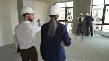 Two architects working on plan of apartment layout