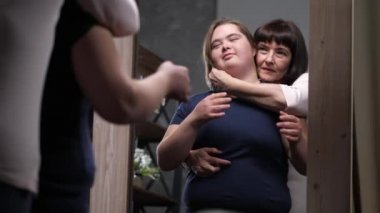 Annemi ve engelli kızı aynayla kucaklamak.
