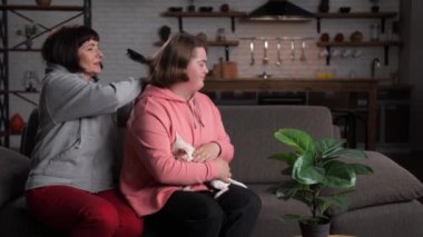 Anne koltuğunda çocuğunun saçını tarıyor.