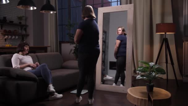 Übergewichtiges behindertes Mädchen blickt auf eigenes Spiegelbild — Stockvideo