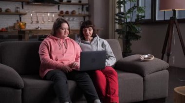 Engelli anne ve kızı tablette sohbet ediyorlar.