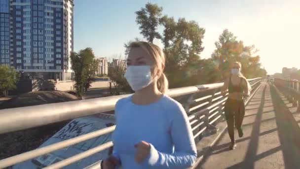 Sportieve vrouwen in medische maskers joggen buiten — Stockvideo