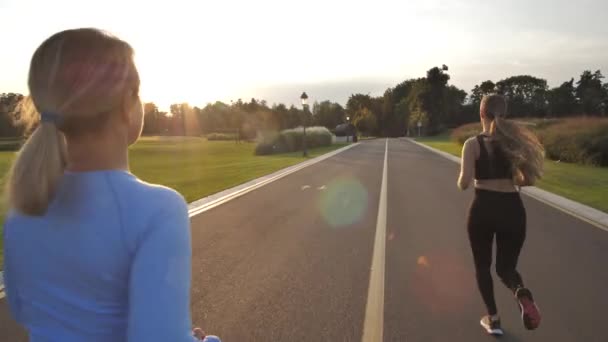 Bionda donne sportive che fanno jogging nel parco durante il tramonto — Video Stock