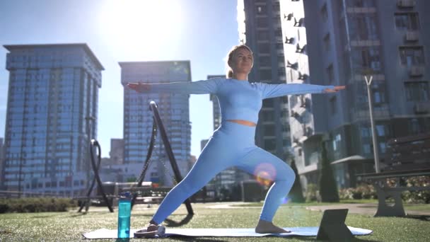 Mujer en forma haciendo ejercicio de yoga entre edificios de la ciudad — Vídeo de stock