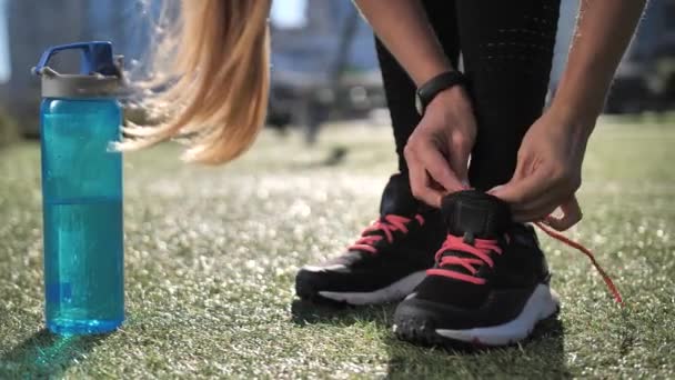 Спортивная женщина, завязывающая шнурки во время городской тренировки — стоковое видео