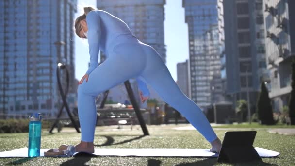 Mujer joven enmascarada haciendo yoga en el patio urbano — Vídeos de Stock