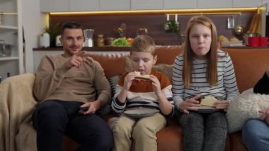 Kanepede oturup televizyon izleyen pozitif sağır aile.