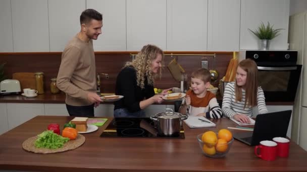 Заботливые глухие родители дают закуски детям дома — стоковое видео