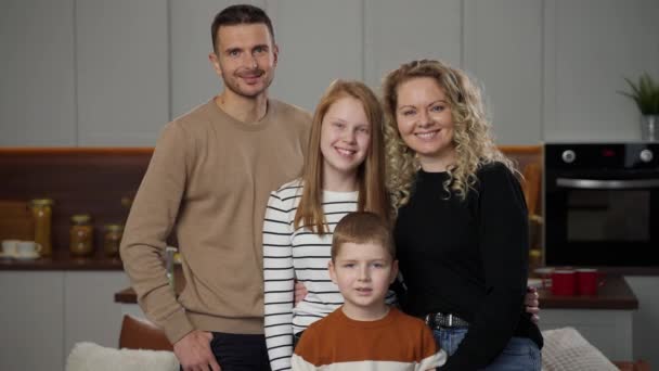 Портрет счастливой семьи, улыбающейся в помещении перед камерой — стоковое видео