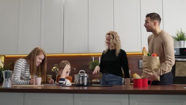 Семья с детьми встречается на кухне — стоковое видео
